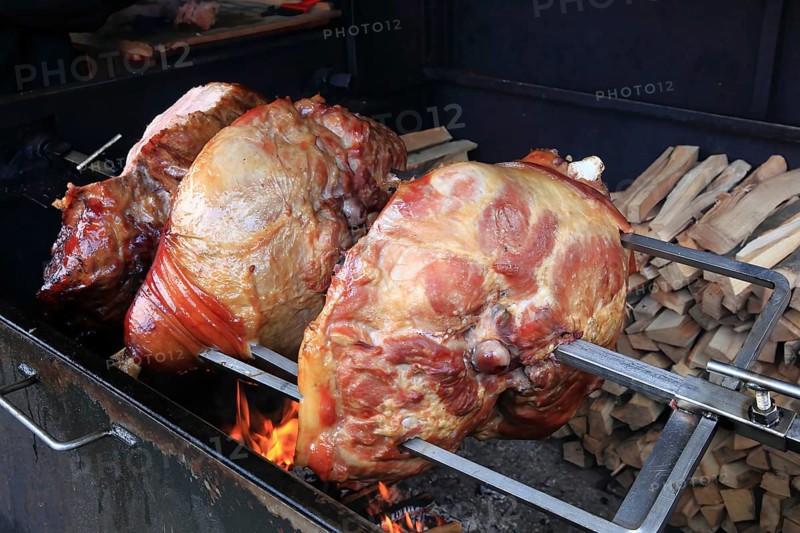 Pork knuckles are grilled on a spit over a wood fire, Prague, Czech Republic, Europe