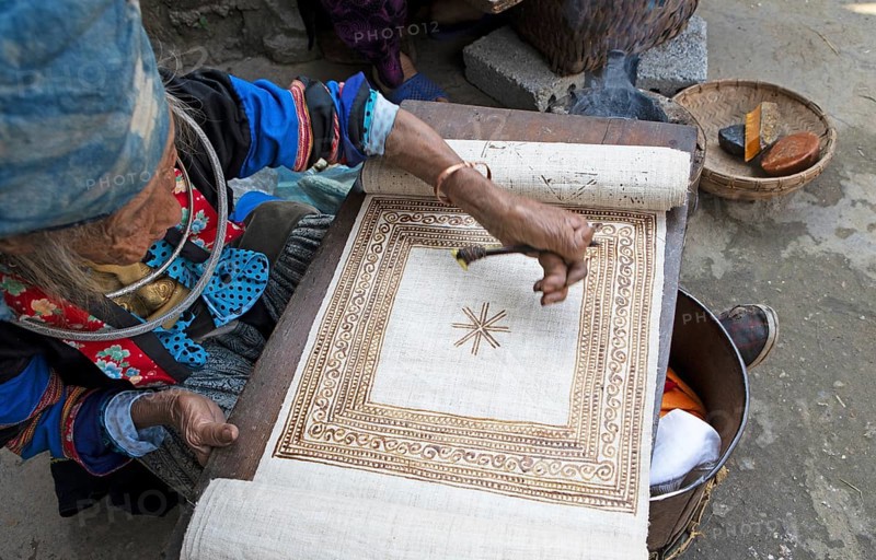 Vietnamese woman from the Hmong minority draws a pattern on linen fabric, Lung Tam linen weaving mill, Ha Giang province, Vietnam, Asia