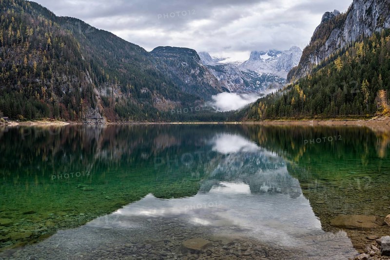 The Vordere Gosausee lake in autumn with a view of the Dachstein mountain range. The Gosaukamm on the right. Cloudy sky. Cloudy lake. Reflection. Vorderer Gosausee, Gosau, Gosau valley, Salzkammergut, Upper Austria, Austria, Europe