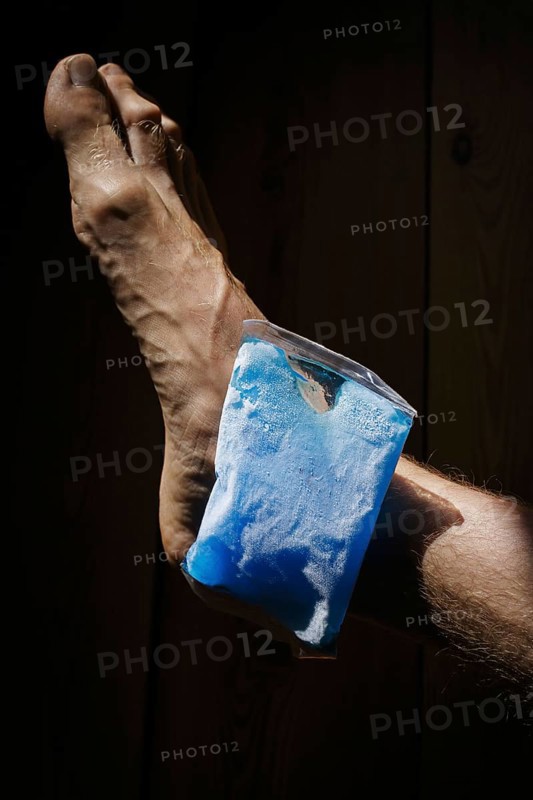 Symbolic photo on the subject of cooling for joint pain. A cooling pad is placed on an ankle and cools the joint. Berlin, 21.08.2024