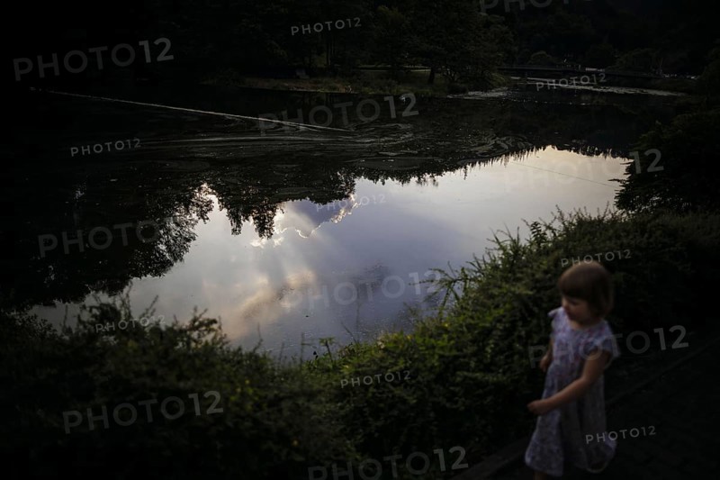 Symbolic photo on the subject of dangers on the water for small children. A little girl runs along the shore of a lake shortly in front of sunset. Ziegenrück, 20.07.2024