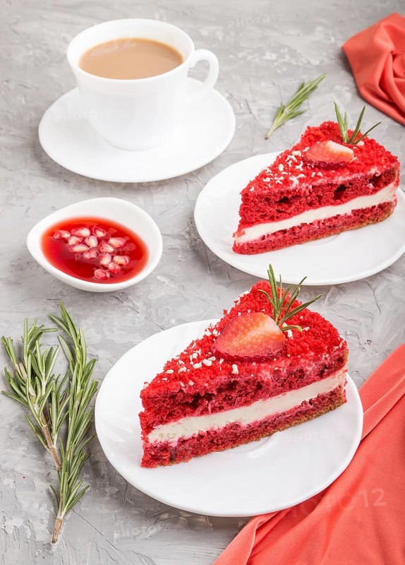 Homemade red velvet cake with milk cream and strawberry with cup of coffee on a gray concrete background with red textile. side view, close up