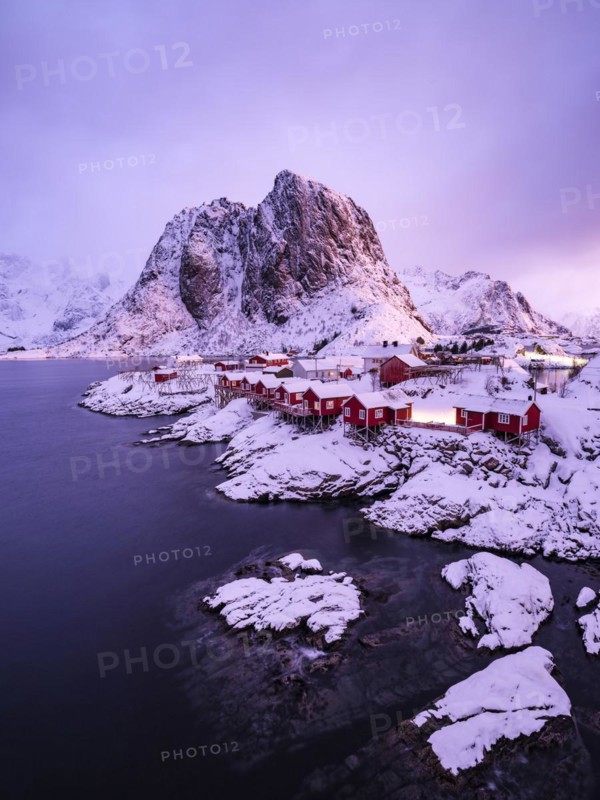 Rorbuer huts of Hamnoy at the fjord in the morning light, snowy mountains in the background, Hamnøy, Reine, Moskenesøya, Lofoten, Norway, Europe
