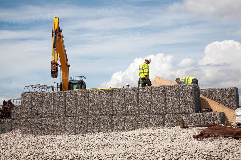 Repair work on steel mesh cages known as gabions which provide coastal defence at Chiswell, Isle of Portland, Dorset, England, UK