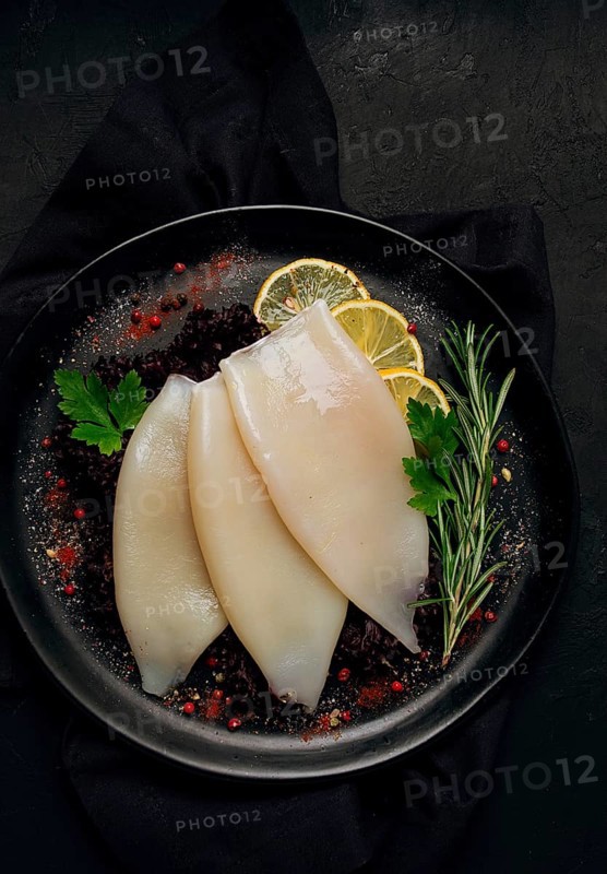 Fresh body, squid, raw, three carcasses, top view, no people, on a plate