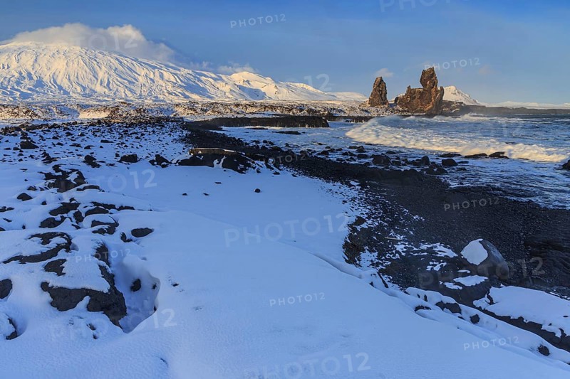 Rocks and surf at the coast, evening light, sun, snow, winter, Arnarstapi, Snaefellsjökull, Snaefellsnes, Vesturland, Iceland, Europe