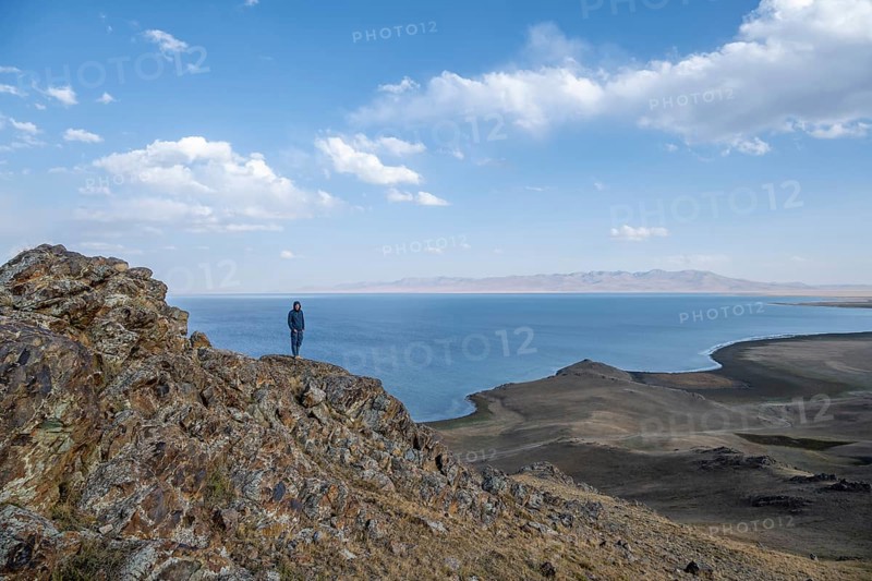 Tourist standing on a hill, view of mountain lake Song Kul, Naryn region, Kyrgyzstan, Asia