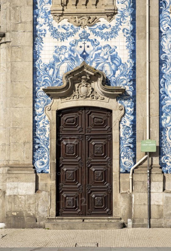 A door set against the blue and white tiled facade of Igreja do Carmo Church, Porto, Portugal, Europe