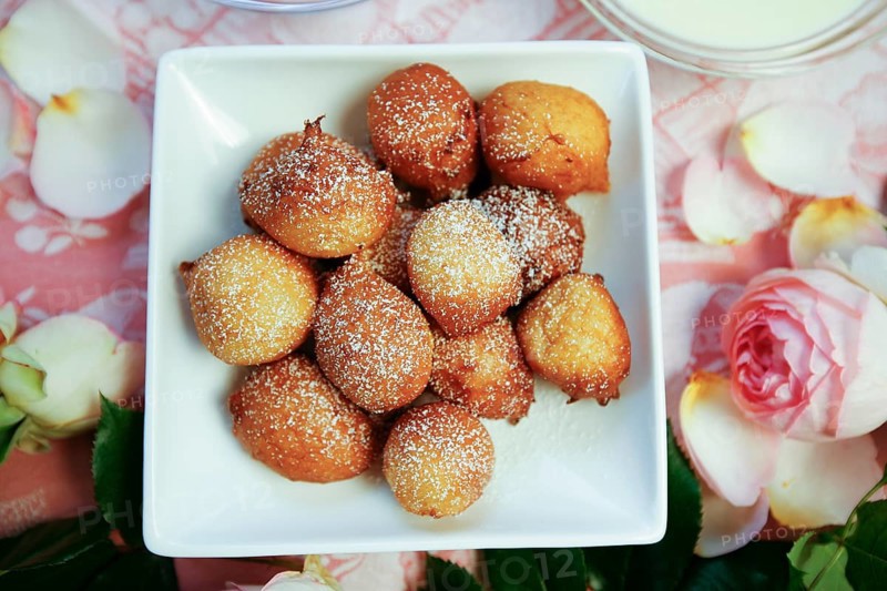 Swabian cuisine, fat baked, Nonnenfürzle, Nonnenfürzchen, Swabian classic, lard baked, Swabian dessert, dessert, typical Swabian, traditional, choux pastry, icing sugar, vanilla sauce, sauce, festive table setting, roses, floral decoration, home cooking, traditional cuisine, food photography, studio, Germany, Europe
