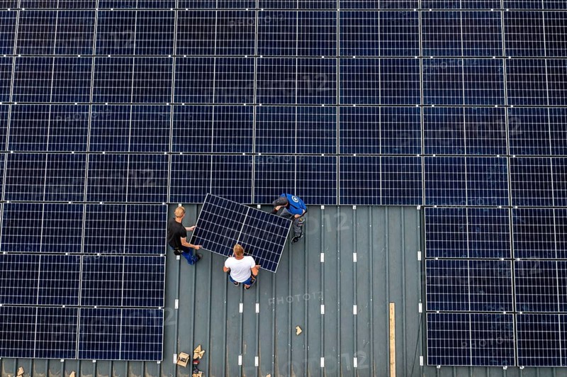 Installation of solar modules on the roof of a barn on a farm, over 210 photovoltaic modules are installed on the roof, North Rhine-Westphalia, Germany, Europe