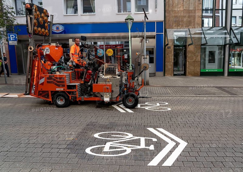 Application of road markings for a cycle lane, Rüttenscheider Straße in Essen, in the shopping and gastronomy district, cyclists have right of way over motorised vehicles, part of a cycle axis through Essen's city centre