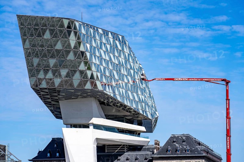 The Antwerp Port Authority building, Havenhuis, former fire brigade barracks in the harbour, renovated and with an attached glass structure, in the shape of a ship's hull, administrative headquarters of the Antwerp Port Authority, designed by Zaha Hadid, building cleaners clean the windows, truck work platform of the German rental company Gerken, Antwerp, Flanders, Belgium, Europe