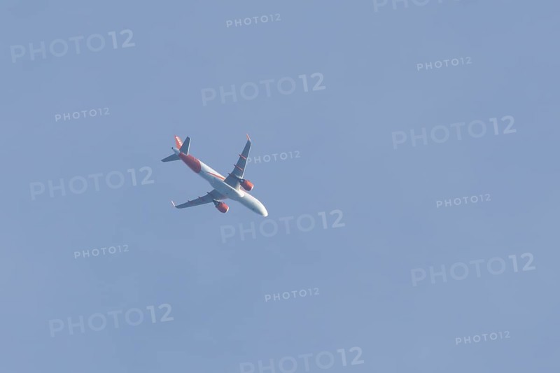 Airbus A320 aircraft of Easyjet airlines in flight across a blue sky, England, United Kingdom, Europe
