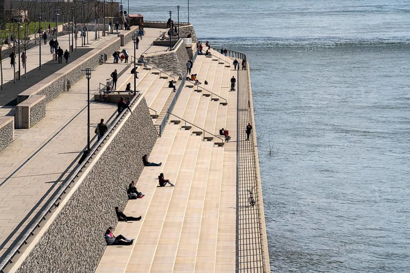 Effects of the coronavirus crisis, Rhine promenade, Rhine boulevard, on the Deutzer Ufer, few people with a lot of distance to each other in the spring sun, Cologne, Germany, Europe