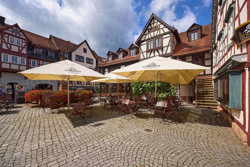 Outdoor area of a restaurant with parasols, tables and chairs on the market square in Michelstadt, Odenwald, Odenwaldkreis, Hesse, Germany, Europe