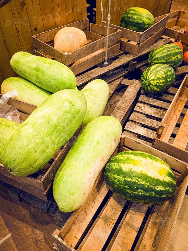 Watermelon variety Snake of Georgia, long green watermelon, watermelons in a wooden box, on pallets, supermarket, lifestyle, no people, mobile photo