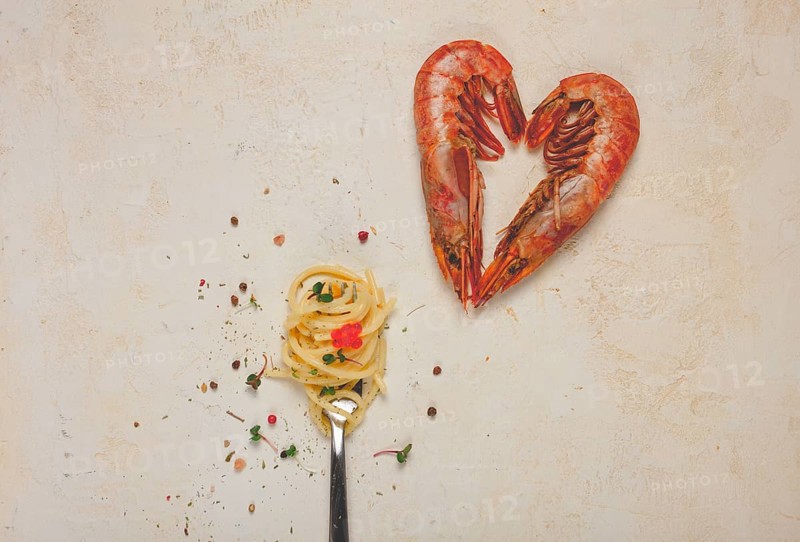 Spaghetti wrapped on a fork, langoustines heart shape, on the table, food concept, food background, top view