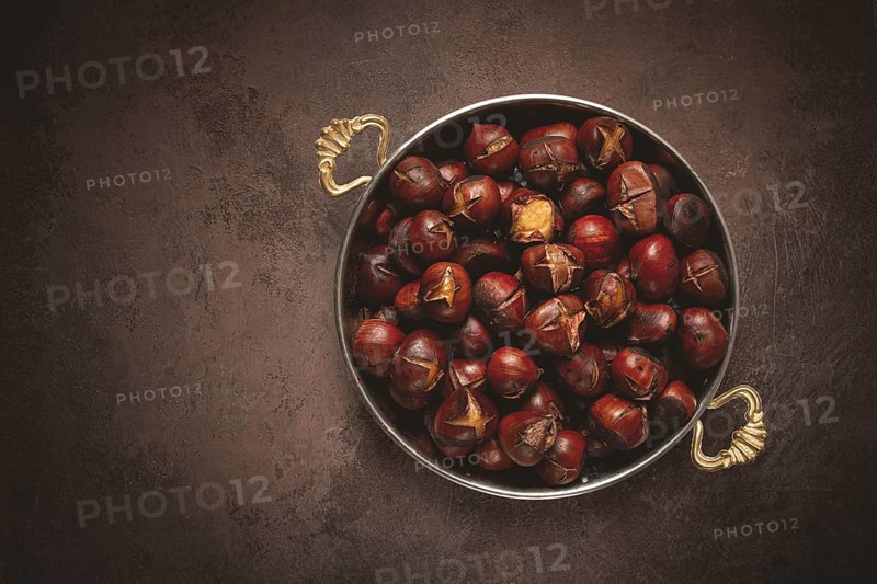 Roasted chestnuts, in a wooden plate, top view, homemade, no people