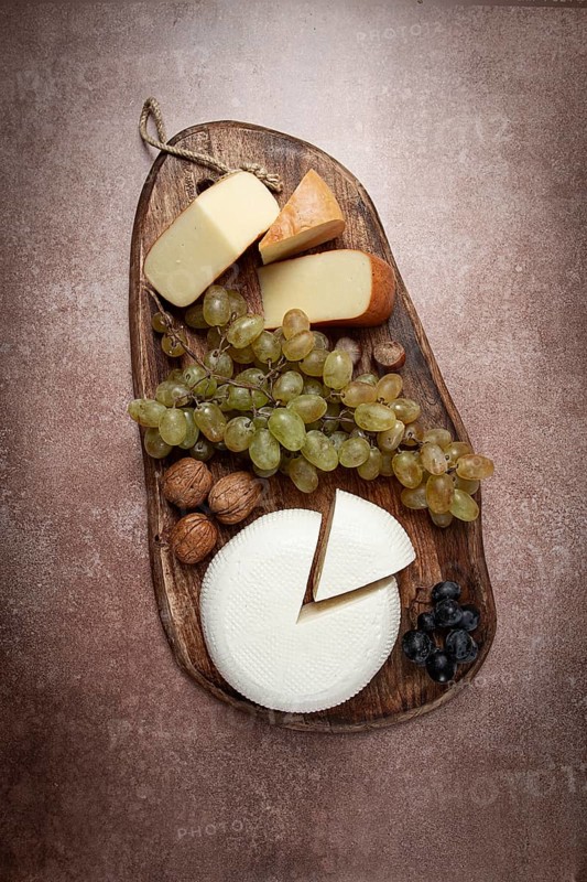 Georgian cheese, Imeretian and smoked suluguni, grapes, nuts, on a cutting board, Georgian cuisine, no people