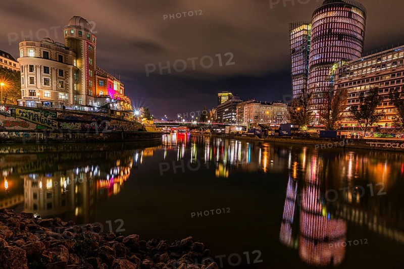 Lights reflected in the Danube Canal, on the left the Urania observatory, on the right illuminated office towers, night shot, Vienna, Austria, Europe