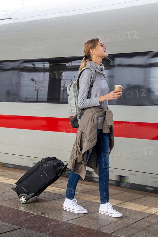 Young woman on the railway track while a train arrives