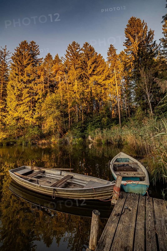 Boats in the autumnal Schmutter Weiher in the Allgäu near the municipalities of Halblech, Roßhaupten and Lechbruck in Ostallgäu in the foothills of the Alps