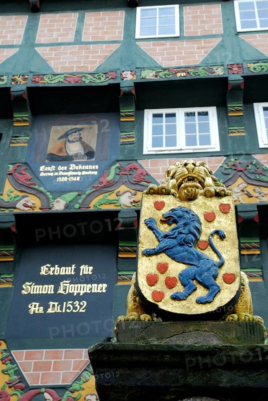 Fountain column with lion, coat of arms and half-timbered house, Hoppener Haus, Celle, Lower Saxony, Germany, Europe