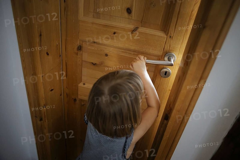 Symbolic photo: A small child opens a door in a flat. Berlin, 21.08.2024