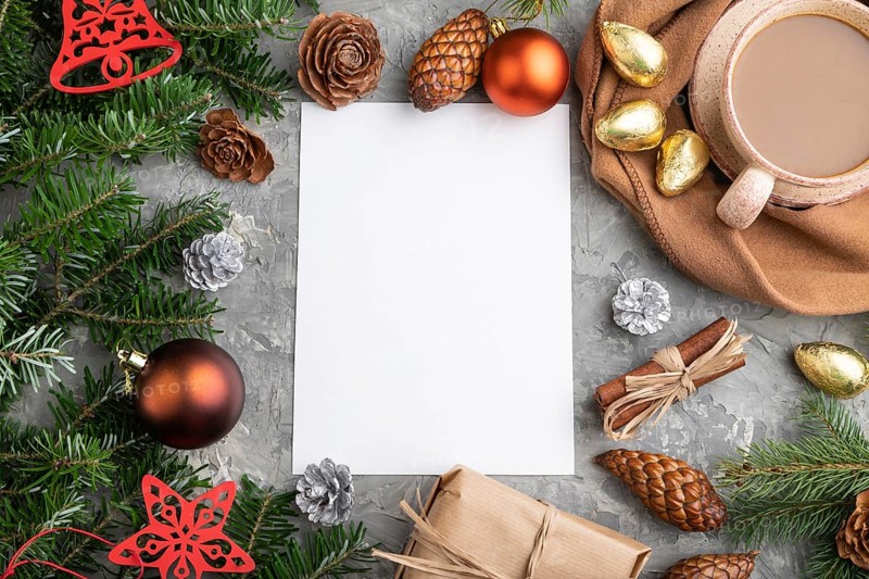 Christmas or New Year frame composition, template. Decorations, cones, cinnamon, fir and spruce branches, cup of coffee, wool scarf on a gray concrete background. Top view, copy space, flat lay