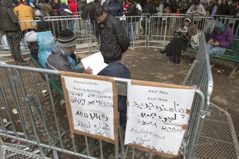 Refugees from Syria waiting to be registered at the Central Reception Centre for Asylum Seekers at the Berlin State Office for Health and Social Affairs, signs indicating waiting numbers, 09/10/2015