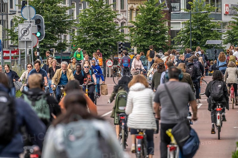 Central cycle path on Smakkelaarskade, at Utrecht Centraall station, in the centre of Utrecht, lanes for pedestrians, cyclists and cars are separated, waiting at traffic lights, heavy traffic, Netherlands