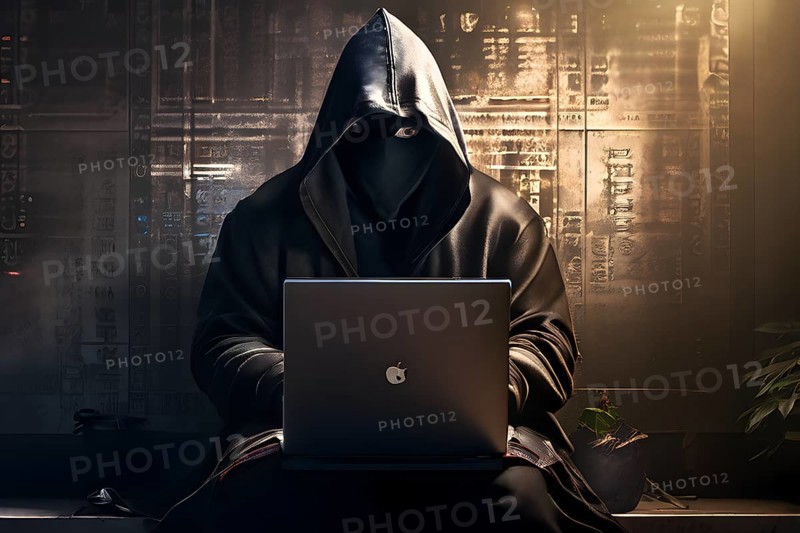 AI generated hooded man clutching a laptop symbolizing cyber criminality