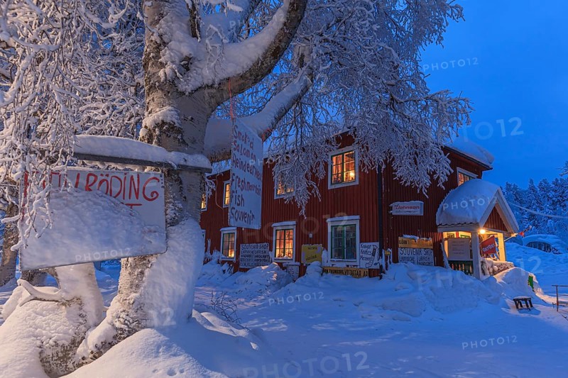 Illuminated Swedish red wooden house, shop, snow, twilight, winter, Porjus, Lapland, Sweden, Europe