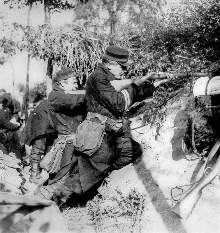 WWI Belgian infantrymen in trench shooting with Mauser Model 1889 bolt-action rifle used during World War One in 1914 in Flanders, Belgium, Europe