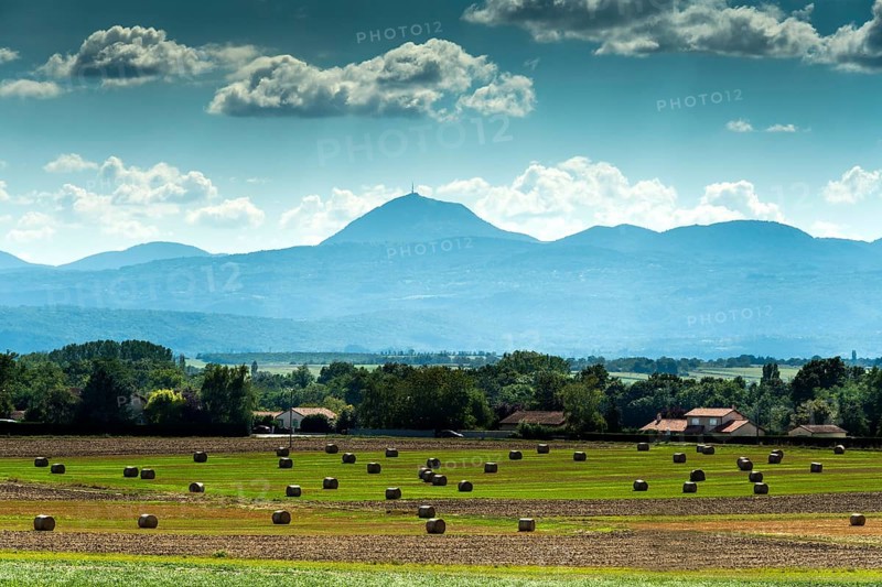 View of the Chain of Volcanoes and Limagne plain under a vibrant sky in Puy-de-Dôme, Auvergne-Rhône-Alpes, France, Europe