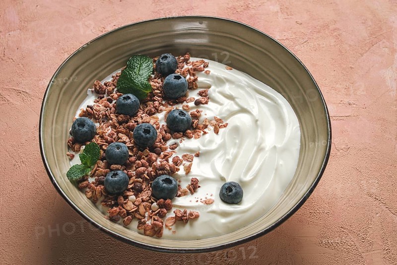 Yogurt with chocolate muesli, with berries, blueberries, breakfast, close-up, fork on top, no people