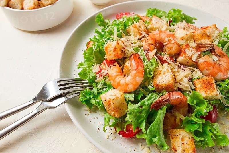 Caesar salad, with shrimp, on a white background, homemade, no people