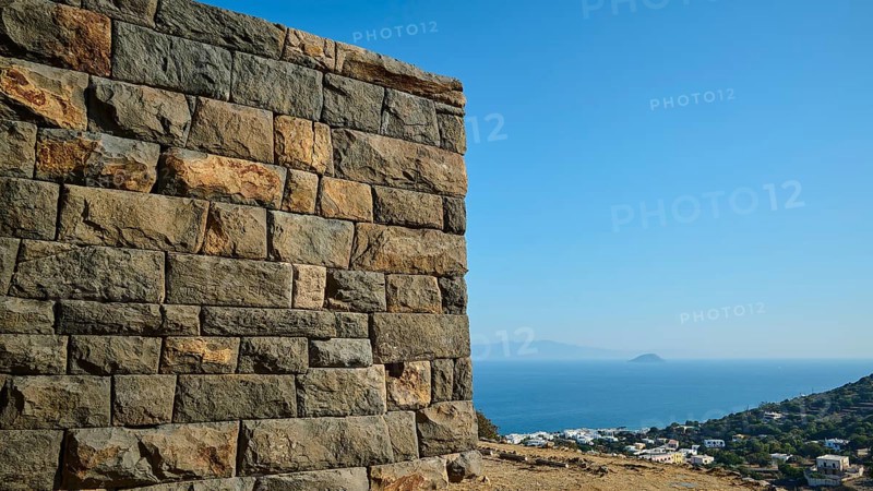 A massive stone structure overlooking the sea and the surrounding landscape under a clear sky, Palaiokastro, Ancient Fortress, 3rd and 4th century BC, above Mandraki, Nisyros, Dodecanese, Greek Islands, Greece, Europe