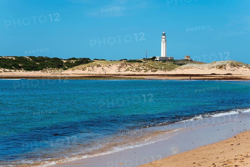 Sandy beach beach with lighthouse in the background, clear blue sea and bright dunes, Faro de Trafalgar, Cape Trafalgar, Cádiz province, Costa de la Luz, Andalusia, Spain, Europe