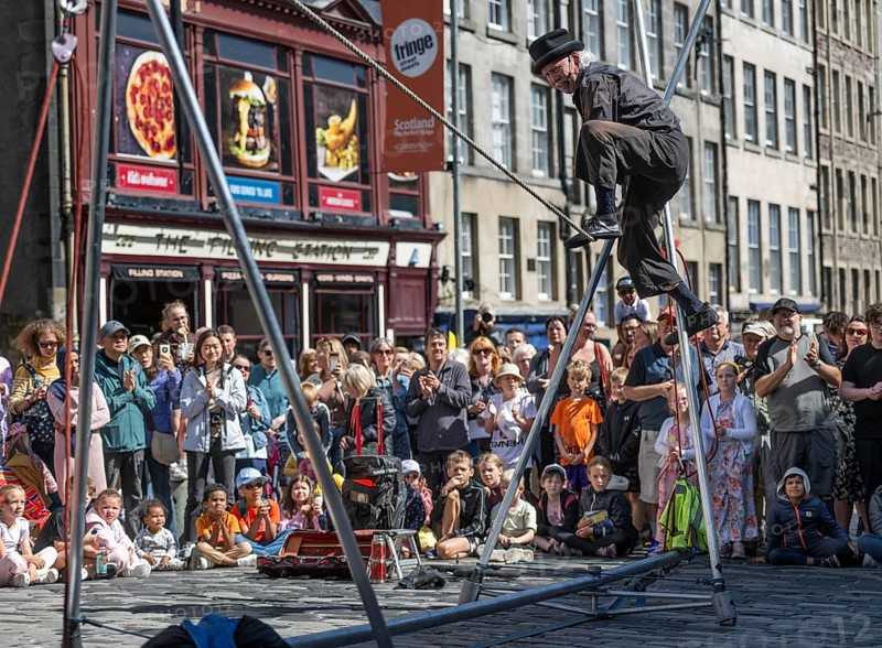 Street performers and spectators at a high-wire acrobatics performance, world's largest cultural festival The Fringe, High Street, Edinburgh, Scotland, United Kingdom, Great Britain, Europe