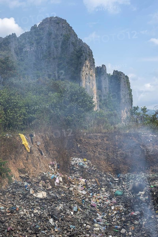 Coking rubbish dump, rubbish pit with waste and plastic rubbish, karst landscape near Vang Vieng, Vientiane province, Laos, Asia