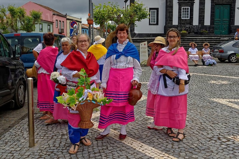 Women in colourful traditional dress stand on a street and smile, Fenais da Luz, Sao Miguel Island, Azores, Portugal, Europe