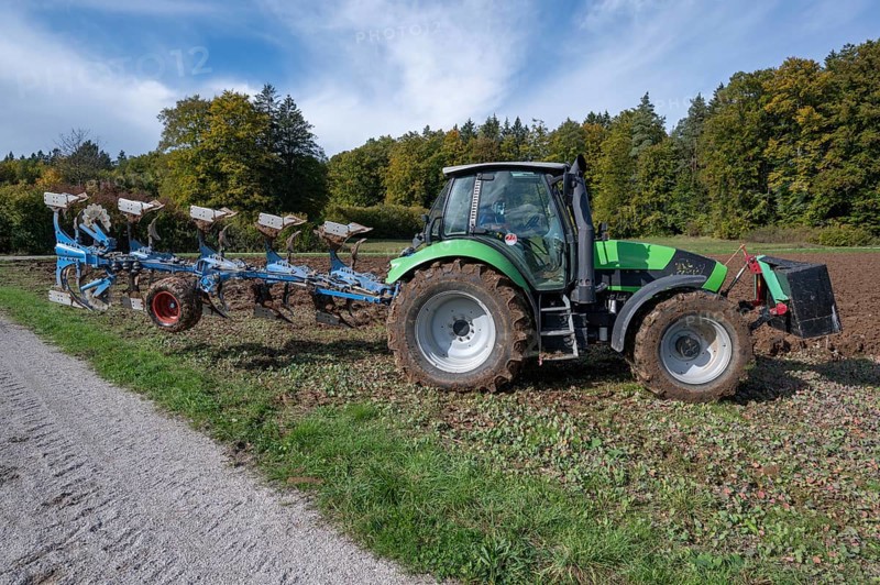 Farmer with tractor ploughing his field with a 5-turn rotary plough, Franconia, Bavaria, Germany, Europe