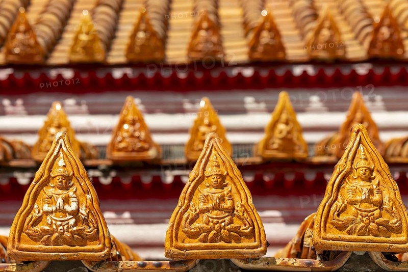 Roof decoration on the Uposatha Hall, Ubosot, the roof is staggered in three tiers and covered with rows of golden yellow glazed Chinese tiles, the last tile of each row at the eaves represents a heavenly angel offering the traditional Thai obeisance Wai to the viewer with folded hands, Wat Benchamabophit, marble temple, Bangkok, Thailand, Asia