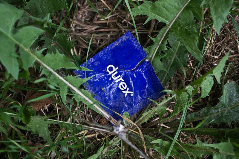 Open condom sachet dumped in nature, France, Europe