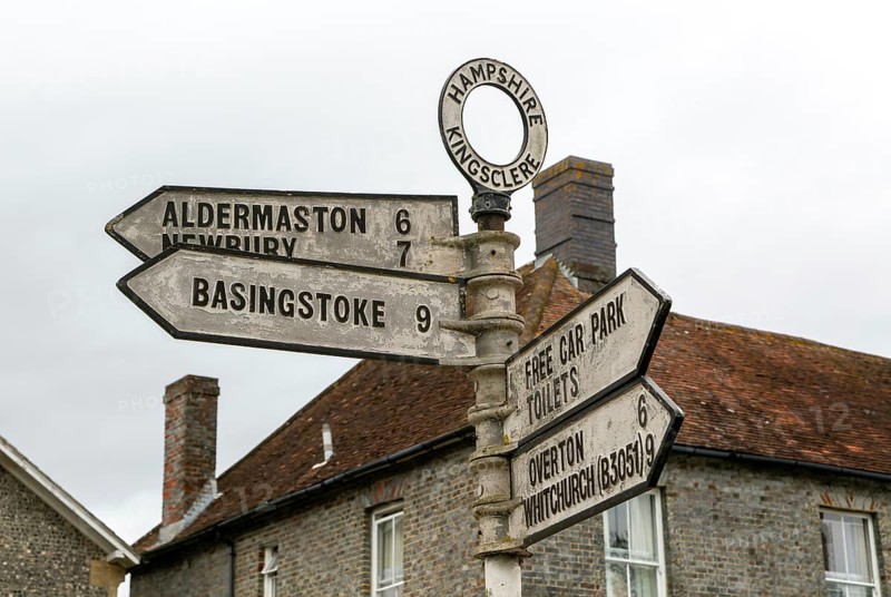 Road signpost arrow pointers and distances to nearby settlements, Kingsclere, Hampshire, England, UK