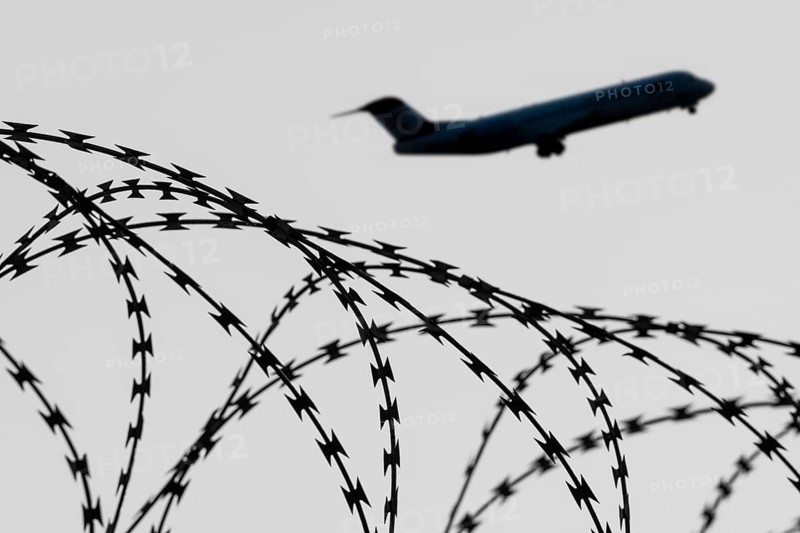 Symbolic image, deportation flights of illegal and delinquent migrants, passenger aircraft, airport, security fence, barbed wire, black and white image, Germany, Europe