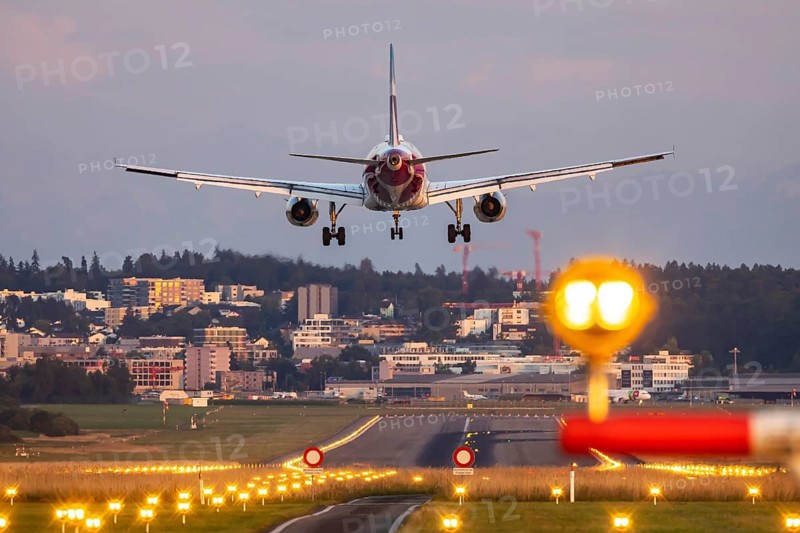 Eurowings aircraft landing in the evening with illuminated runway. Zurich Airport, Switzerland, Europe