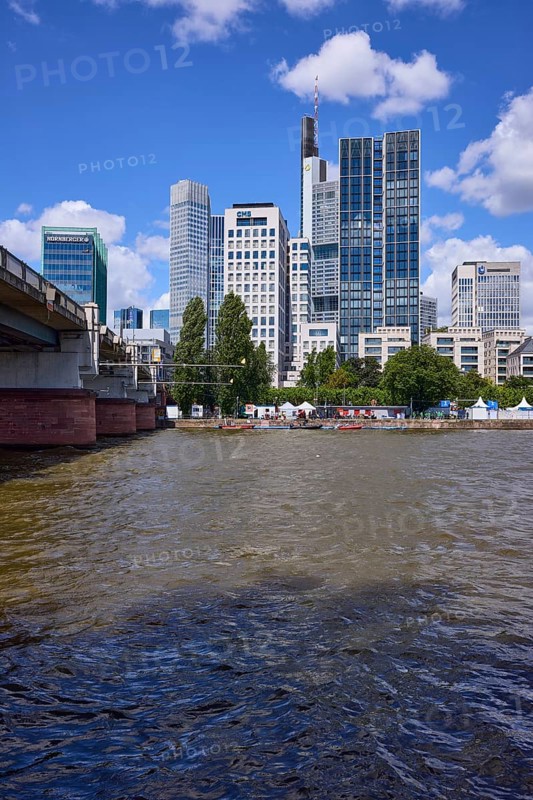 Skyscrapers and Untermainbrücke with Main river under blue sky with cumulus clouds in Frankfurt am Main, Hesse, Germany, Europe
