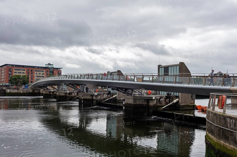 Modern designed bridge spanning a river under a cloudy sky, Belfast
